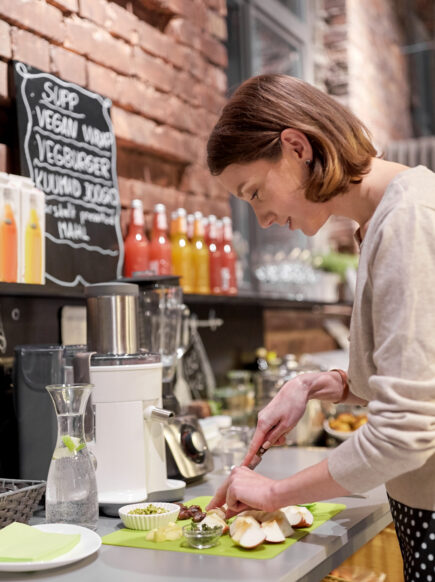 Woman prepares food at plant-based cafe